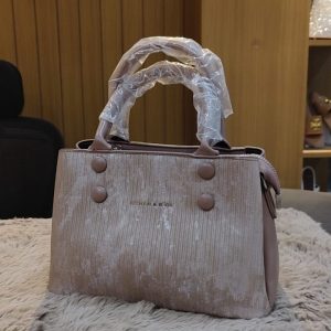 Rose pink velvet-textured handbag with button detailing and double handles wrapped in protective plastic.