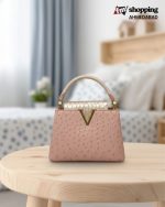 Pink ostrich texture top handle bag with metallic crocodile print 'V' closure.