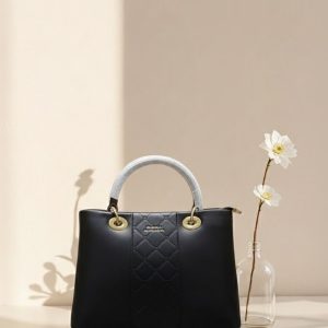 Black quilted tote bag with gold hardware displayed on marble counter